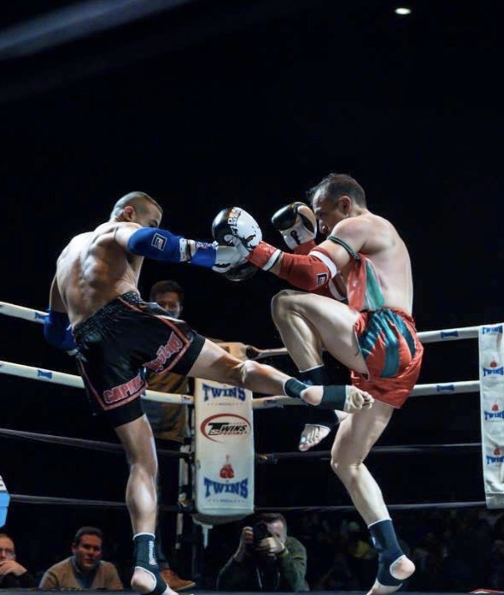 Muay Thai fighters exchanging strikes in the ring